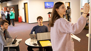 Students working on whiteboard in a group