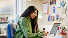 Female student working at desk in accommodation