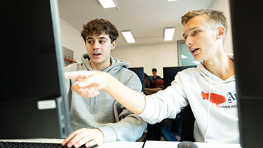 Two male students working together in a computer lab
